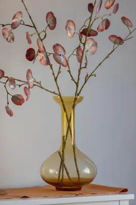 a yellow vase with flowers in it on a table at Comfortable Two-Bedroom Apartment Strzelców by Noclegi Renters in Kraków