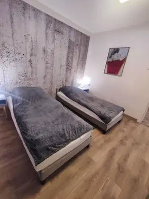 two beds in a room with a wall at Apartamenty na Maciejową in Rabka-Zdroj