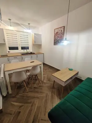 a kitchen with a table and chairs in a room at Apartamenty na Maciejową in Rabka-Zdroj