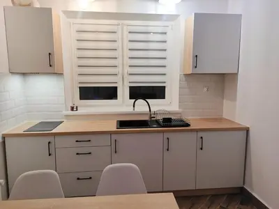 a kitchen with white cabinets and a sink and a window at Apartamenty na Maciejową in Rabka-Zdroj