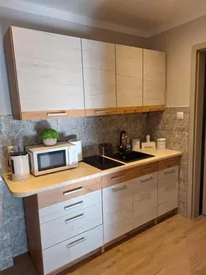 a kitchen with white cabinets and a microwave at Lawendowy zakątek in Graboszyce