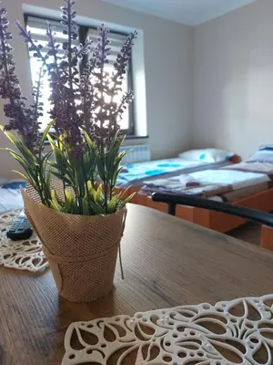 a vase with purple flowers sitting on a table at Lawendowy zakątek in Graboszyce