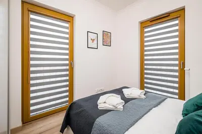 a bedroom with a bed with two white towels on it at Deluxe residence apartment in Kraków