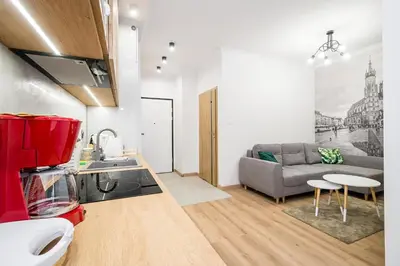 a kitchen and living room with a couch and a table at Deluxe residence apartment in Kraków