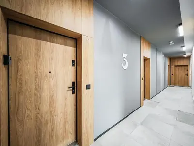 a row of wooden doors in a hallway at Deluxe residence apartment in Kraków
