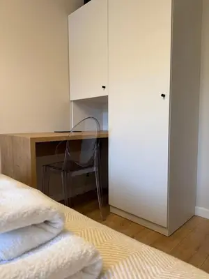 a bedroom with a bed and a desk with a chair at M&S Apartment in Kraków