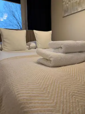 a pile of towels sitting on top of a bed at M&S Apartment in Kraków