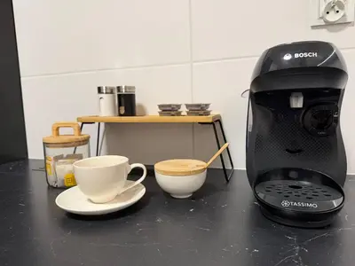 a coffee maker and two cups on a counter at M&S Apartment in Kraków