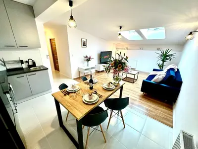 a kitchen and living room with a table and chairs at COZY OLD-Town Apartments at Kazimierz +AC, KITCHEN and NETFLIX in Kraków