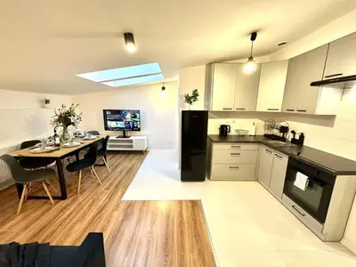 a kitchen and dining room with a table in it at COZY OLD-Town Apartments at Kazimierz +AC, KITCHEN and NETFLIX in Kraków