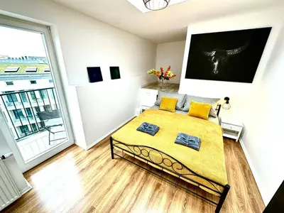 a bedroom with a bed and a large window at COZY OLD-Town Apartments at Kazimierz +AC, KITCHEN and NETFLIX in Kraków