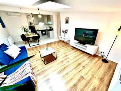 a living room with a couch and a flat screen tv at COZY OLD-Town Apartments at Kazimierz +AC, KITCHEN and NETFLIX in Kraków