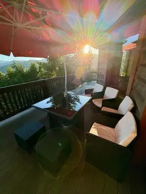 a balcony with a table and chairs on a deck at Uroczysko pod Mogielicą in Szczawa