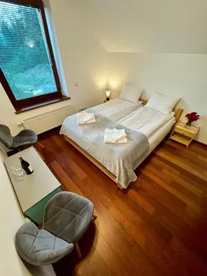 a bedroom with a bed and a chair and a window at Uroczysko pod Mogielicą in Szczawa