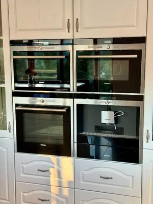 three ovens in a kitchen with white cabinets at Uroczysko pod Mogielicą in Szczawa