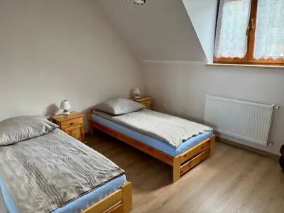 a bedroom with two twin beds and a window at Apartament w Budzowie in Budzów