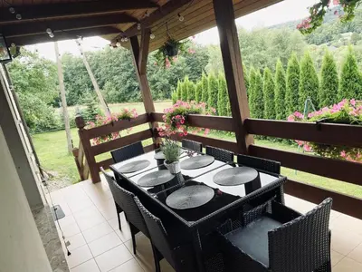 a patio with a table and chairs and flowers at Apartament w Budzowie in Budzów