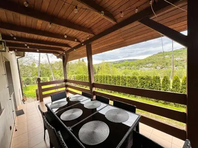 a dining room with a table and chairs on a porch at Apartament w Budzowie in Budzów