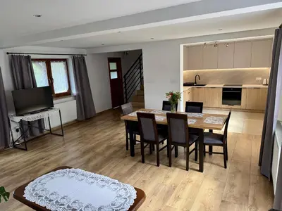 a dining room and kitchen with a table and chairs at Apartament w Budzowie in Budzów
