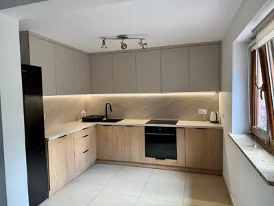 a kitchen with wooden cabinets and a sink at Apartament w Budzowie in Budzów