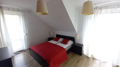a bedroom with a bed with two red pillows at House between Cracow and Wieliczka in Wieliczka