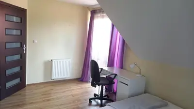 a bedroom with a desk and a chair in front of a window at House between Cracow and Wieliczka in Wieliczka