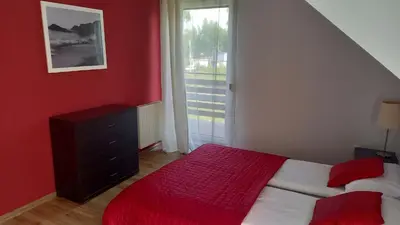 a red bedroom with a bed and a window at House between Cracow and Wieliczka in Wieliczka