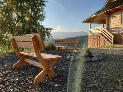 a wooden bench sitting next to a cabin at Domek na Zawojskim Przysłopiu in Zawoja