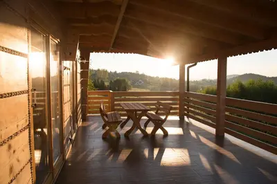 a wooden porch with a table and benches on it at Domek na Zawojskim Przysłopiu in Zawoja