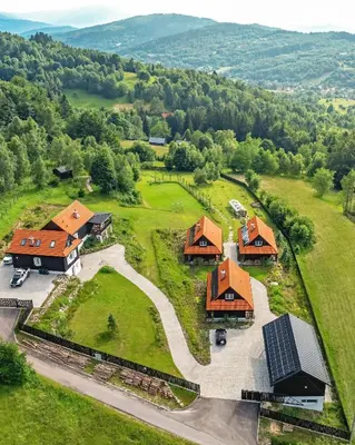 an aerial view of a farm with a group of houses at U Pana Boga za piecem - domki w górach, Sauna, Beskidy, Koszarawa in Korbielów