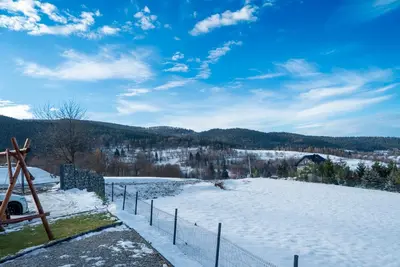 a snow covered hill with a fence on top of it at Widokowe Stodoły balia z hydromasażem na wylączność in Chyszówki
