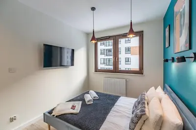 a bedroom with a bed and a tv and a window at Tauron Arena Modern Apartment - Parking and Balcony by Rentujemy in Kraków