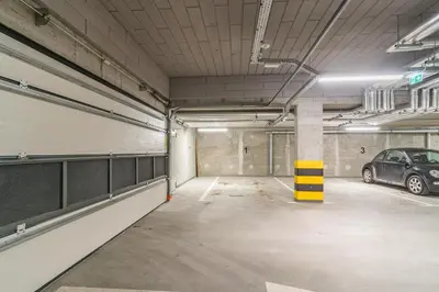 a parking garage with a car parked in it at Tauron Arena Modern Apartment - Parking and Balcony by Rentujemy in Kraków