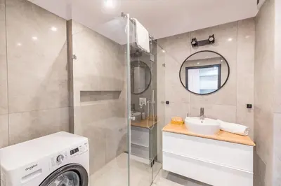 a bathroom with a washing machine and a sink at Tauron Arena Modern Apartment - Parking and Balcony by Rentujemy in Kraków