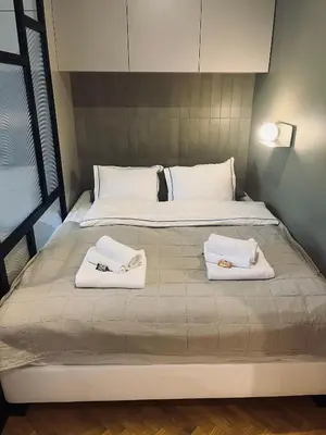 a large bed with two white towels on it at Apartament BonHaus WiślaneTarasy in Kraków