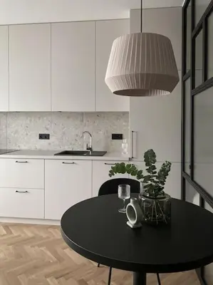 a white kitchen with a black table and a sink at Apartament BonHaus WiślaneTarasy in Kraków