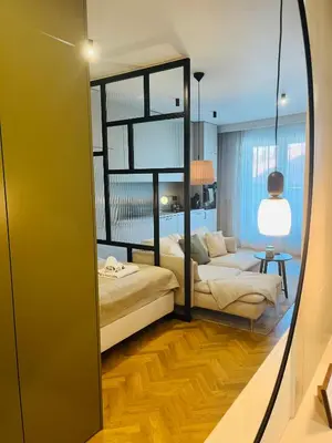 a mirror in a room with a bed and a couch at Apartament BonHaus WiślaneTarasy in Kraków