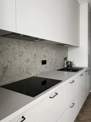 a kitchen with white cabinets and a black counter top at Apartament BonHaus WiślaneTarasy in Kraków