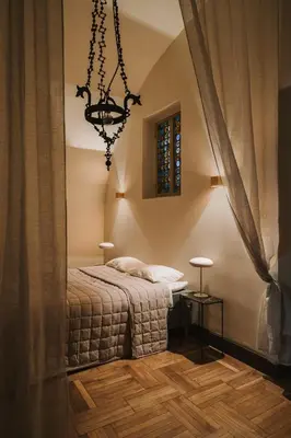 a bedroom with a bed and a chandelier at HERE Apartments in Kraków