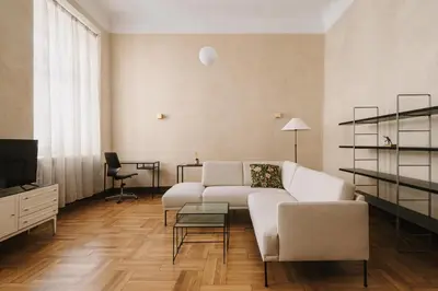 a living room with a white couch and a tv at HERE Apartments in Kraków