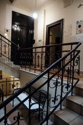 a staircase in a building with a black railing at Yellow Window Apartment in Kraków