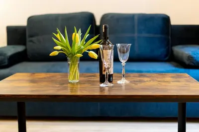 a table with a bottle of wine and two glasses at Yellow Window Apartment in Kraków
