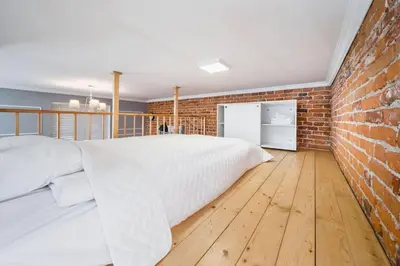 a bedroom with a bed and a brick wall at Vélo Apartment, High Standard, TV, WiFi in Kraków