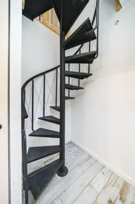 a black spiral staircase in a room with a wooden floor at Vélo Apartment, High Standard, TV, WiFi in Kraków