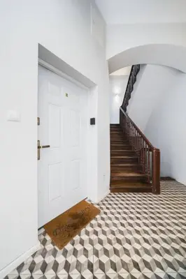 a hallway with a white door and a staircase at Vélo Apartment, High Standard, TV, WiFi in Kraków