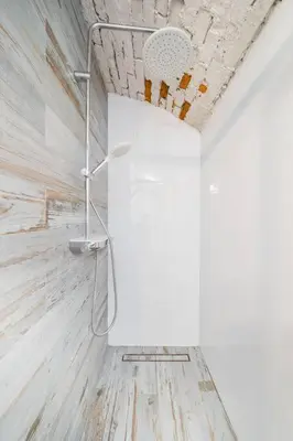 a shower in a bathroom with a white wall at Vélo Apartment, High Standard, TV, WiFi in Kraków