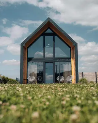 a glass house with chairs in it on a field at Bocianie Gniazdo w Rabce in Rabka-Zdroj