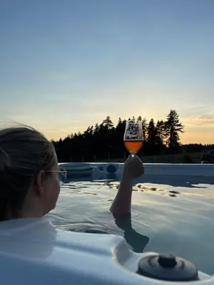 a woman holding up a glass in a bathtub at Bocianie Gniazdo w Rabce in Rabka-Zdroj