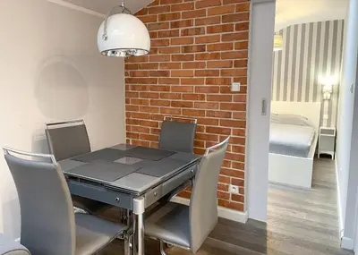 a dining room with a brick wall and a table and chairs at Z&M apartments - Cracow Old Town in Kraków