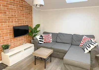 a living room with a couch and a brick wall at Z&M apartments - Cracow Old Town in Kraków